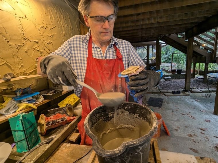 Mixing cement in the Gnome and Garden workshop, with molds on the bench