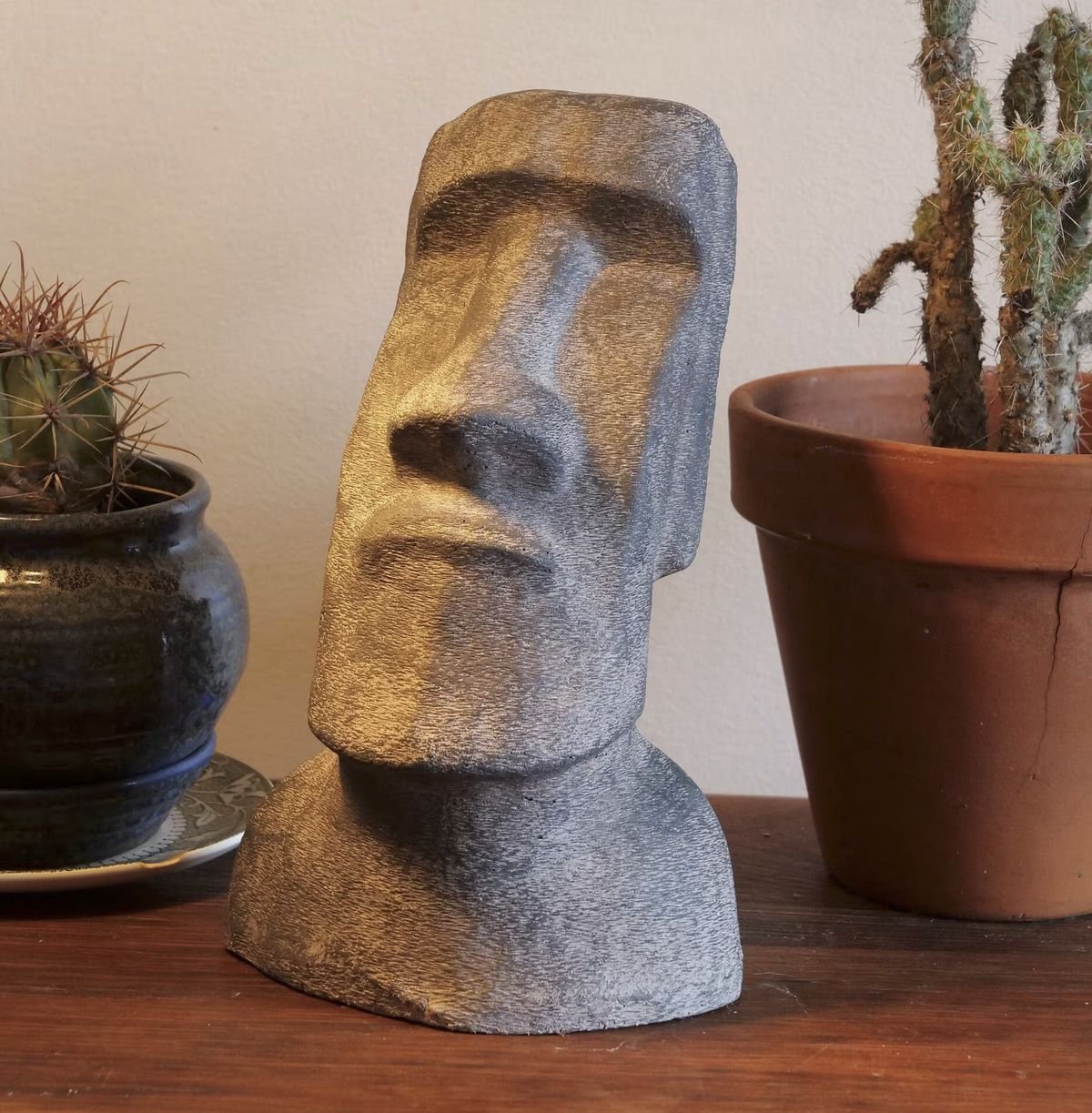 A small cement statue on a shelf indoors